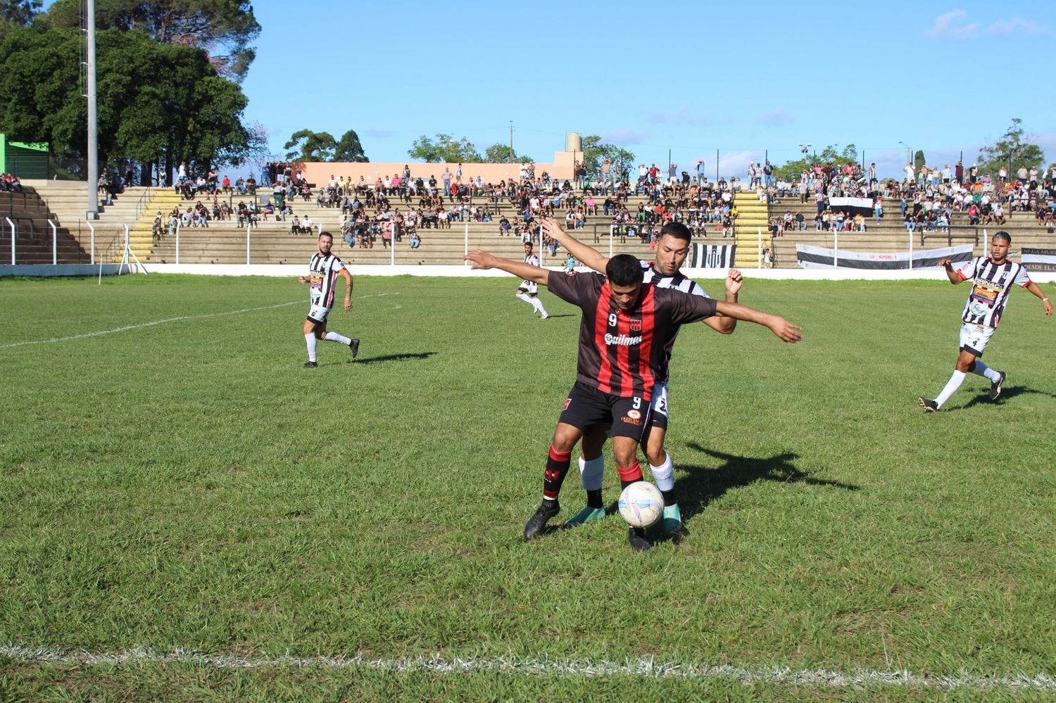 Jonathan Campoamor aguanta la pelota ante la marca de un jugador de Victoria (foto: Darío Piriz).